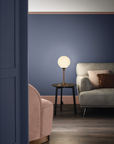 A living room with blue walls and a pink couch, adorned with luxury lighting from Masiero, including a Masiero Tee Table Lamp.