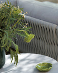 An Sifas Basket Sofa Collection with a vase of flowers on a table featuring waterproof properties.
