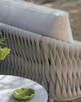 An Sifas Basket Sofa Collection with a vase of flowers on a table featuring waterproof properties.