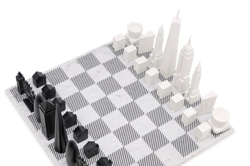 A chess board featuring the Skyline Chess Acrylic 2 City London New York Marble Board, with black and white chess pieces inspired by the iconic skylines of London and New York.