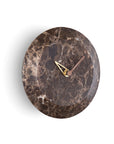 A Nomon Bari S Emperador HUGSE levitating marble clock on a white wall.