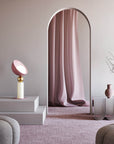 A versatile and vibrant lighting design from the Aurora Collection by Italamp featuring brushed gold accents, white glass diffuser, and retro-inspired finishes. A pink and ivory finish table lamp styled on steps in a pink theme design set by interior stylist navin kanodia of spacio mumbai