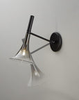 Baffo Collection by Italamp with conical design, titanium finish glass, and matching metal accents, showcasing Italian craftsmanship and elegance. A black and platinum finish baffo wall lamp showing the movement of adjusted