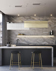 Discover the Carmen collection by Italamp – Italian Murano glass lighting in clear, smoke, and teak finishes. Elegant designs for luxurious interiors. A rectangular suspension of 2 pcs in teak and clear finish over a kitchen pantry counter in a luxury interior
