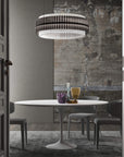 A round chandelier installation in smoke and clear glass in above a round dining table in a modern theme interior of a luxury home. Discover the Carmen collection by Italamp – Italian Murano glass lighting in clear, smoke, and teak finishes. Elegant designs for luxurious interiors.