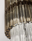 A side view of the smoke and clear glass of the pendant lamp. Discover the Carmen collection by Italamp – Italian Murano glass lighting in clear, smoke, and teak finishes. Elegant designs for luxurious interiors.