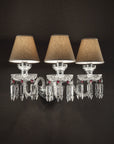 Chanel Collection chandelier by Italamp with carved crystal, chrome-finished metal, and dove fabric diffusers, showcasing Italian luxury and timeless design. A chanel wall light with 3 shades on a black wall along with clear and red crystals