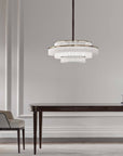 Charles Collection suspension lamp by Italamp featuring gold nickel finish, satin glass elements, and leather accents, epitomising Italian luxury lighting design. A Charles chandelier above a wooden dining table in a modern luxury interior