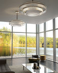 Charles Collection suspension lamp by Italamp featuring gold nickel finish, satin glass elements, and leather accents, epitomising Italian luxury lighting design. A pair of Charles chandelier in a luxury outhouse with windows next to a water body above a centre table in a living room