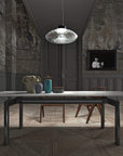 A pendant light above a marble dining table in a modern theme interior. Cicla collection by Italamp, featuring handmade Balloton glass lamps in transparent, white, and smoked finishes with grooved Vicenza stone bases and metal accent.