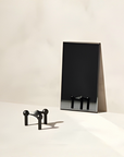 A minimalist black metal candle holder from Stoff Nagel reflection on a mirror