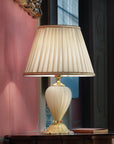 A Venetian cream colour glass table lamp with fabric shade on a round coffee table in a modern contemporary luxury interiors