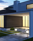 Modern house exterior with floor lamps from Masiero & lit up windows at dusk
