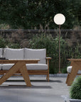 Outdoor furniture set with wooden table and chairs in a garden setting and a floor lamp.