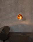 Terzani Mizu Pendant Light Spacio India in cognac finish above an ottoman.
