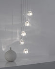 Terzani Mizu Pendant Italian crystal light in silver dust finish, cluster of 5 pcs styled next to a Japandi theme ceramic vase. Available at Spacio retail stores in Mumbai & Kolkata.