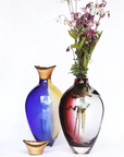 Two colorful vases with one containing flowers on a white background