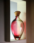 Sculptural Vase on a light shelf against a dark background