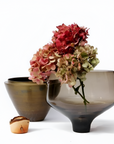 Two decorative vases with flowers on a white background