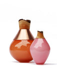 Two decorative vases, one orange and one pink, with wooden tops on a white background.