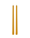 Two tall, thin led taper candles in a warm mustard yellow color, standing upright side-by-side against a solid white background.