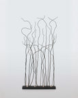 Decorative metal floor lamp with branch-like patterns on a light gray background