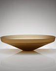 A shallow, wide oval glass bowl with a smooth, tapered design, shown on a reflective white surface against a neutral gray gradient background.