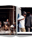 Assouline New York Chic coffee table book displaying photos of Men reading newspaper & a Rapper on white back ground available at Spacio India for luxury home decor accessories collection of Travel Coffee Table Books.