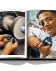 Assouline Louis Vuitton Manufactures coffee table book displaying photo of craftsman working on clock making on white background at Spacio India for luxury home decor collection of Fashion Coffee Table Books.