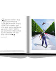 Assouline Louis Vuitton: Virgil Abloh Classic Cartoon Cover coffee table book displaying photo of Virgil Abloh flying a paper plane & quote on a white back ground available at Spacio India for luxury home decor accessories collection of Fashion Coffee Table Books.