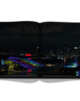 Assouline Louis Vuitton: Virgil Abloh Classic Cartoon Cover coffee table book displaying photo of 'Virgil was here' on the night sky by Louis Vuitton on a white back ground available at Spacio India for luxury home decor accessories collection of Fashion Coffee Table Books.