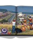 Assouline Formula 1: The Impossible Collection coffee table book people watching race in 1986 from a distance on a white back ground available at Spacio India for luxury home decor collection of Ultimate & Sports Coffee Table Books.