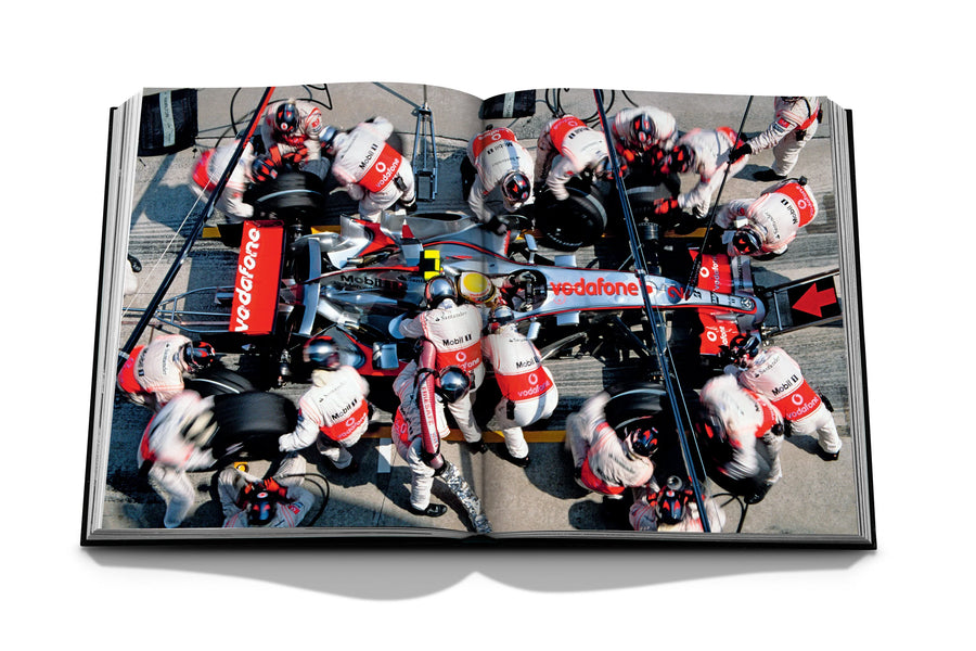 Assouline Formula 1: The Impossible Collection coffee table book McLaren MP4-22,  Car model with other people on a white back ground available at Spacio India for luxury home decor collection of Ultimate & Sports Coffee Table Books.