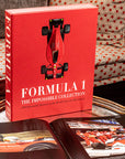 Assouline Formula 1: The Impossible Collection coffee table book on a coffee table with other opened book in a warm ambiance interior available at Spacio India for luxury home decor collection of Ultimate & Sports Coffee Table Books.