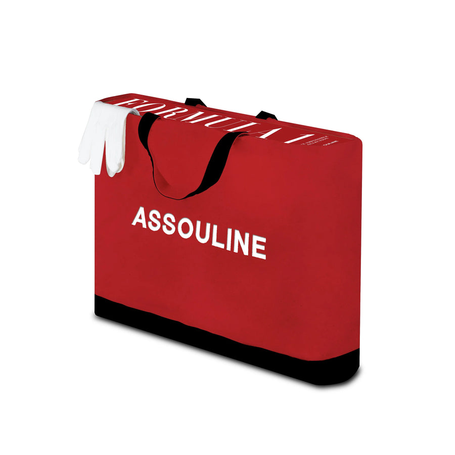 Red Carry Bag of Assouline Formula 1: The Impossible Collection coffee table book on a white back ground available at Spacio India for luxury home decor collection of Ultimate & Sports Coffee Table Books.