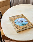 Assouline James Bond: Destinations coffee table book on a round table in modern interior available at Spacio India for luxury home decor accessories collection of Travel Coffee Table Books.
