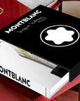 Assouline Montblanc coffee table book on a red center table with a bowl available at Spacio India for luxury home decor accessories collection of Fashion Coffee Table Books.