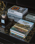 Assouline Paris Chic coffee table book on a coffee table with decor accessories - books & diffuser in cozy interior table decor ground available at Spacio India for luxury home decor accessories collection of Travel Coffee Table Books.