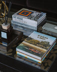 Assouline Paris Chic coffee table book on a coffee table with decor accessories - books & diffuser in cozy interior table decor ground available at Spacio India for luxury home decor accessories collection of Travel Coffee Table Books.
