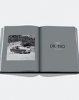 An open book or magazine spread on a light gray background. The left page shows a black-and-white photograph of a vintage convertible car driving outdoors, and the right page has the text '1962 DR.