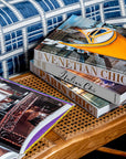 Assouline Venetian Chic coffee table book on side table with other travel books available at Spacio India for luxury home decor accessories collection of Travel Coffee Table Books.