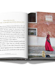 Assouline Venetian Chic coffee table book page picturing a lady at a place of venice city on a white back ground available at Spacio India for luxury home decor accessories collection of Travel Coffee Table Books.
