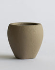 Textured brown ceramic vase on a light gray background