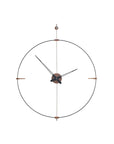 A Clock Nomon Mini Bilbao MBI with a sleek circular design hanging on a wall.