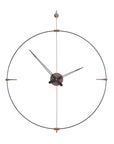 A Clock Nomon Mini Bilbao MBI with a sleek circular design hanging on a wall.