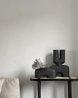 A 101Cph Cobra Double Medio Coffee 211037 vase in the brand of 101 Copenhagen sits on a table in a quirky living room interior setting.