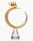 Decorative object resembling a Phoenix with a gold head and clear base on a white background