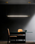A high-end room with a table and chairs adorned with decorative lighting from the Esperia Eredania Horizontal Suspension Light.