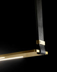 A high-end Esperia Eridania Horizontal Suspension Light, featuring a decorative gold and black pendant, hanging elegantly on a sleek black background.