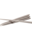 Six slim, light beige sticks, likely wax sticks or applicator sticks, arranged in a crossed pattern on a solid white background by Ester & Erik, available at Spacio in India.